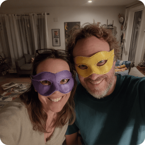 Couple portant des masques violet et jaune dans son salon